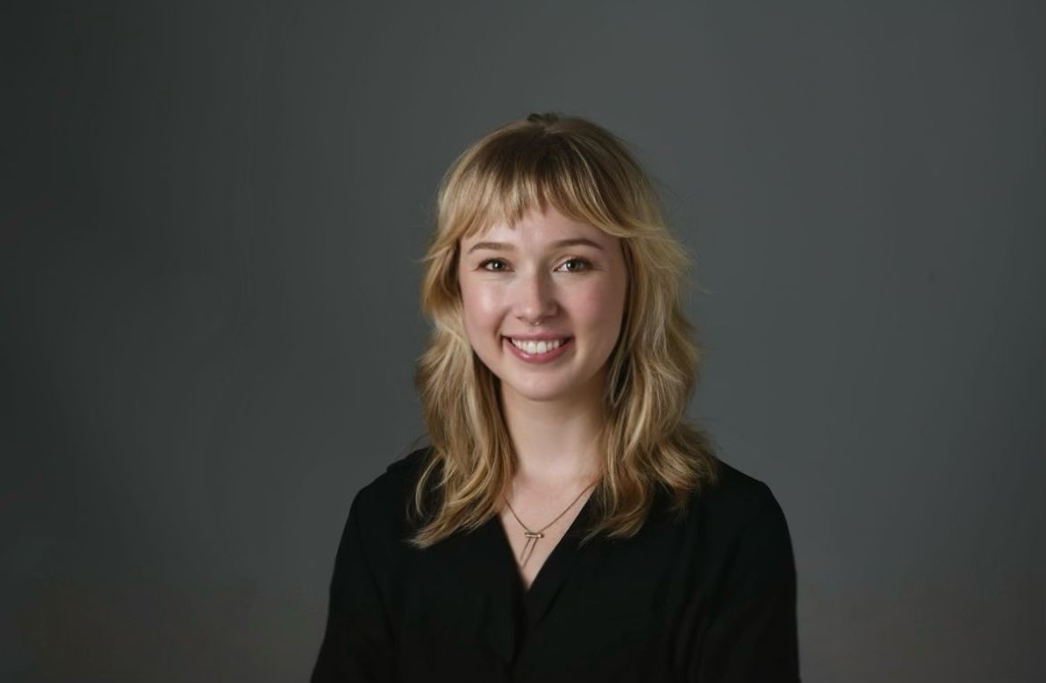 Portrait of Annie Koppes against a grey studio backdrop.